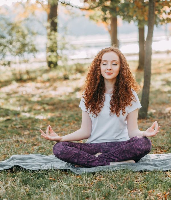 Person meditating peacefully in a bright, natural setting.